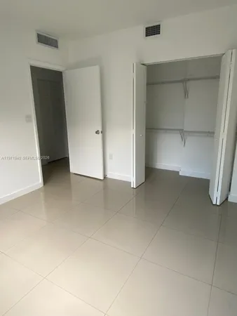 an empty room with a bench and closet