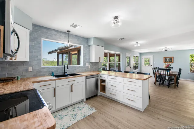 a kitchen with white cabinets and sink