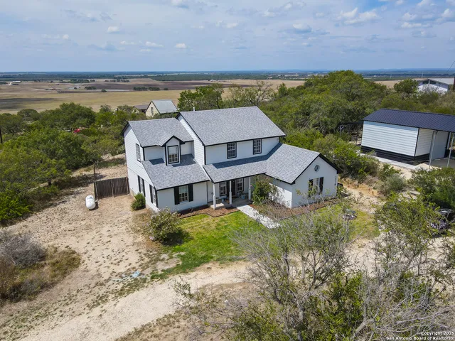 an aerial view of residential houses with outdoor space and ocean view