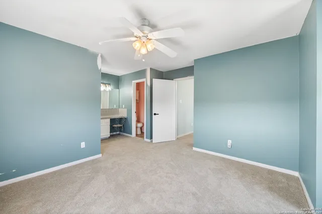 an empty room with fan and windows