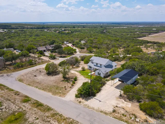 an aerial view of ocean and residential houses with outdoor space