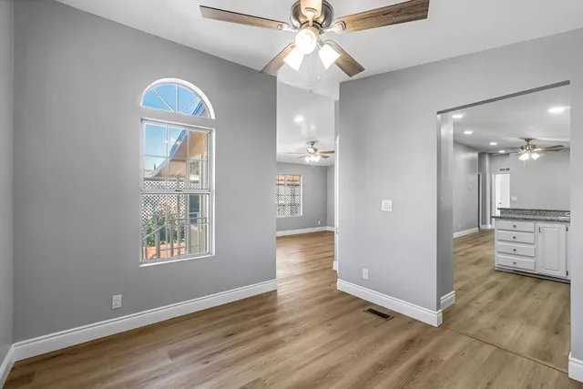 a view of a kitchen with wooden floor and a ceiling fan
