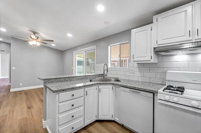 a kitchen with granite countertop cabinets stainless steel appliances a sink and a window