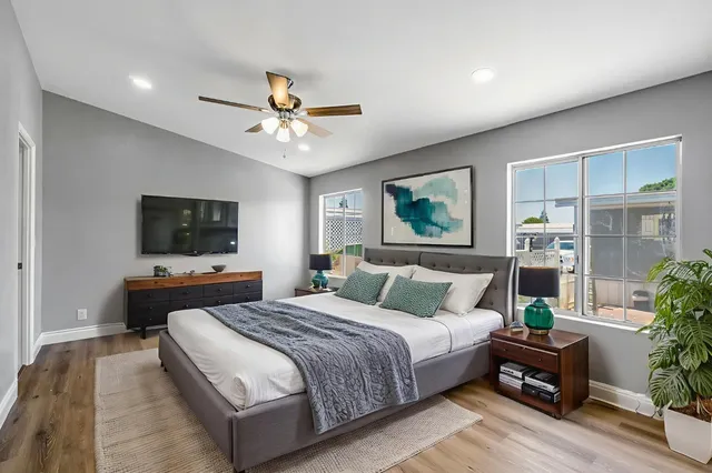 a bedroom with a bed a couch and a flat screen tv