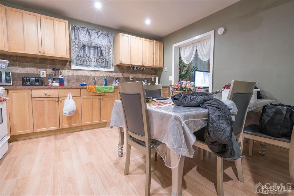 77 Center Street Perth Amboy, NJ 08861 - Photo 23 of 28 a kitchen with stainless steel appliances granite countertop a stove top oven a sink dishwasher and white cabinets with wooden floor