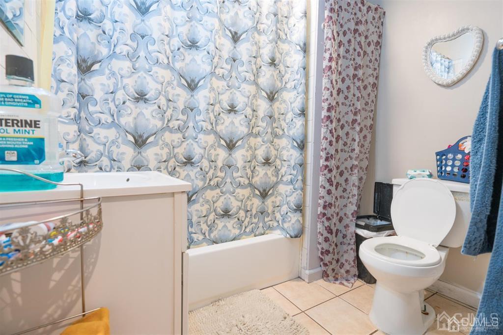 77 Center Street Perth Amboy, NJ 08861 - Photo 24 of 28 a white toilet sitting next to a bathroom sink