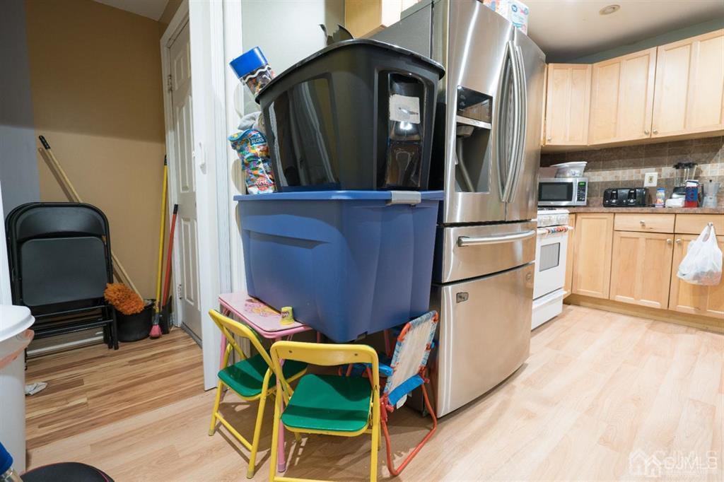 77 Center Street Perth Amboy, NJ 08861 - Photo 25 of 28 a kitchen with stainless steel appliances kitchen island granite countertop a refrigerator a stove and a wooden cabinets