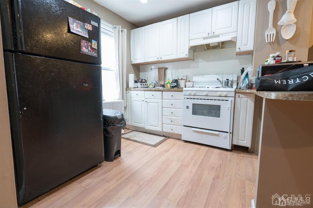 77 Center Street Perth Amboy, NJ 08861 - Photo 10 of 28 a kitchen with a refrigerator stove and cabinets