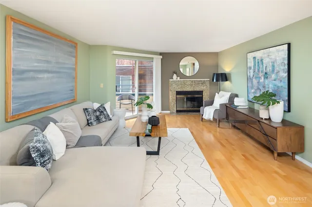 a living room with furniture a fireplace and a large window