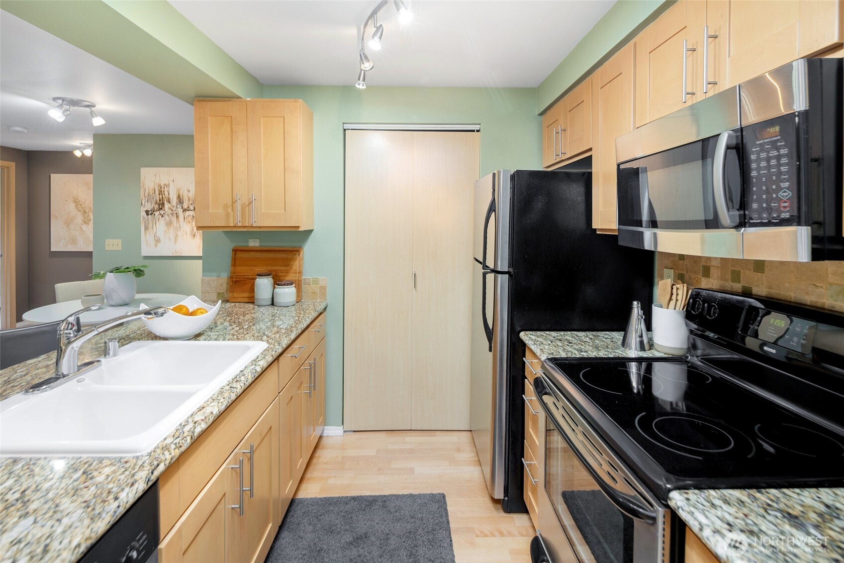 6960 California Avenue Southwest, Unit A308 Seattle, WA 98136 - Photo 10 of 22 a kitchen with stainless steel appliances granite countertop a sink stove and refrigerator
