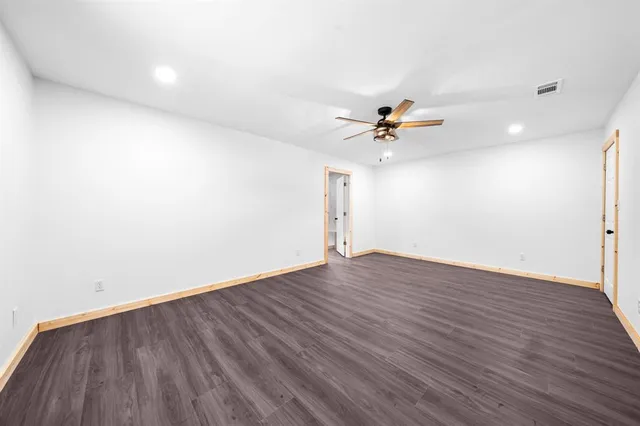 a view of a room with wooden floor and a ceiling fan