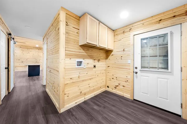 a view of a hallway with wooden floor and cabinet