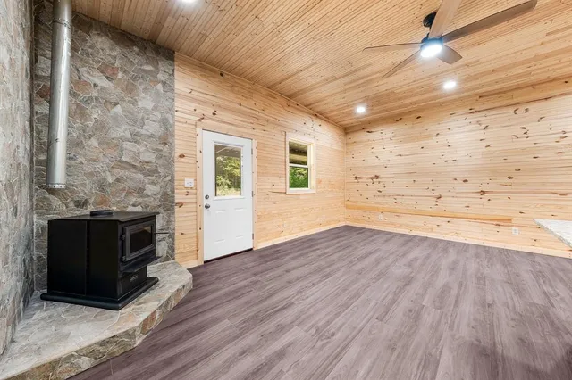 a view of empty room with wooden floor and fireplace