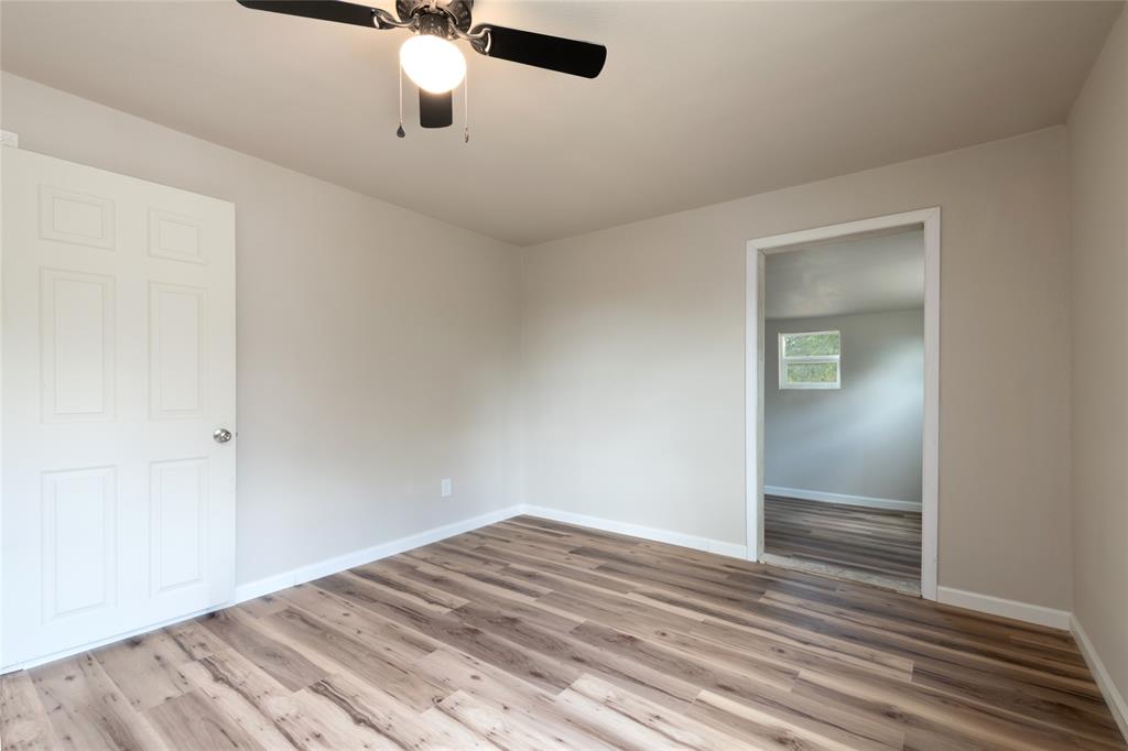 3001 Old Anson Road Abilene, TX 79603 - Photo 8 of 16 Spacious room featuring wood-finish flooring, light neutral wall paint, and a ceiling fan with integrated lighting