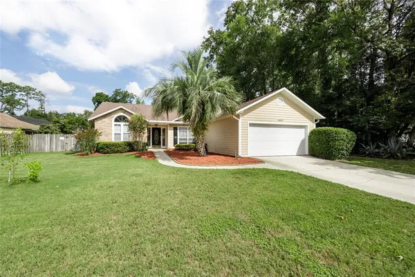 a front view of a house with yard and tree