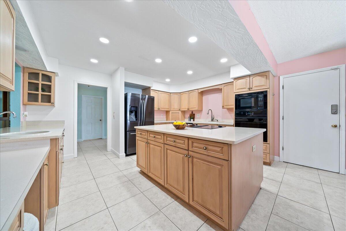 271 Sandy Run Melbourne, FL 32940 - Photo 13 of 41 a kitchen with stainless steel appliances granite countertop a large counter top a sink and a refrigerator