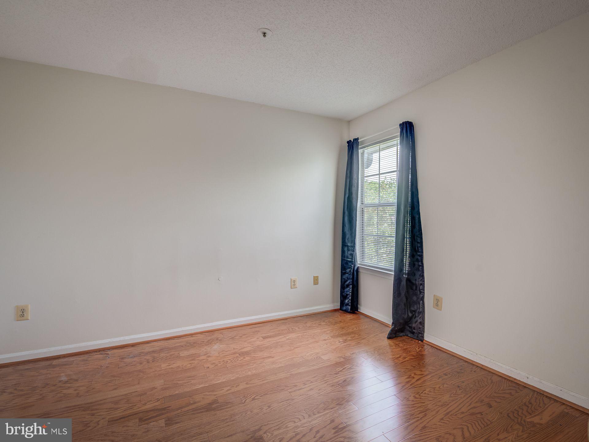 14059 Vista Drive, Unit 141 Laurel, MD 20707 - Photo 22 of 33 an empty room with wooden floor and window