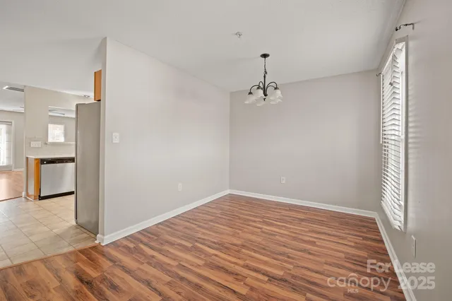 a view of a room with wooden floor and a hallway