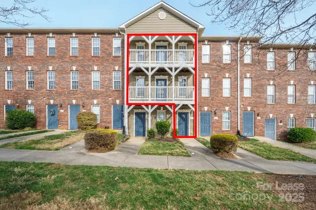 a front view of multi story residential apartment building with a yard