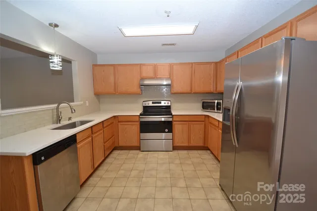 a kitchen with a sink refrigerator and microwave