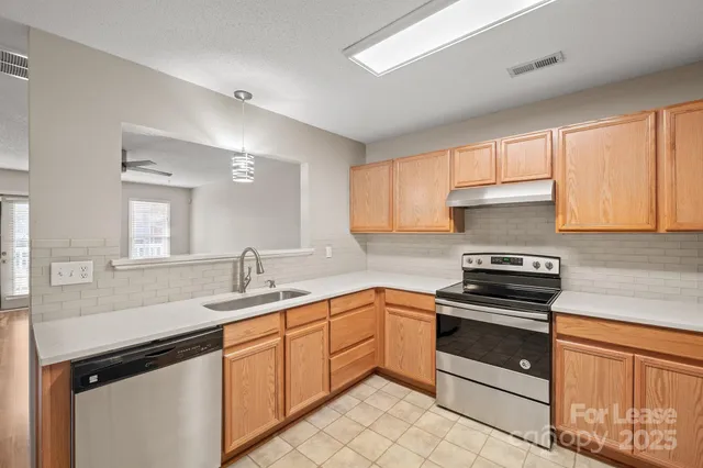 a kitchen with a sink stove and cabinets