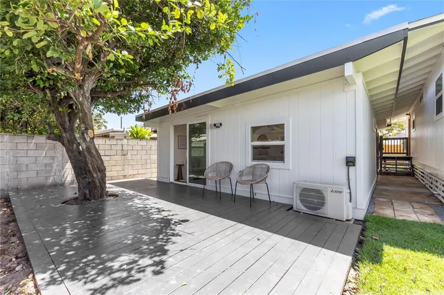 a view of a patio with table and chairs with wooden floor and fence