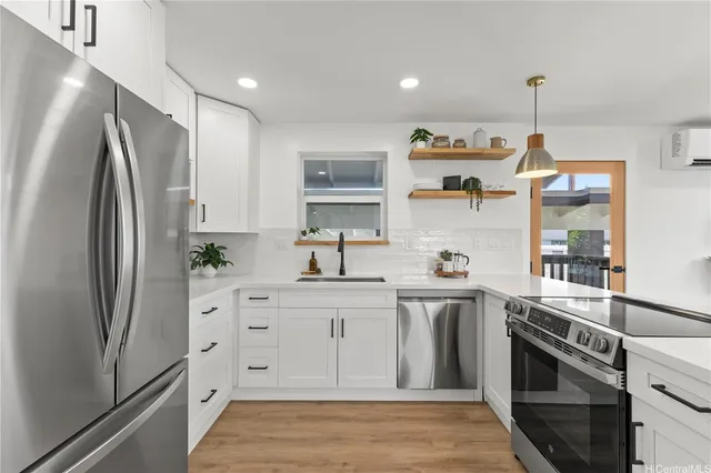 a kitchen with stainless steel appliances granite countertop a refrigerator a stove and a sink