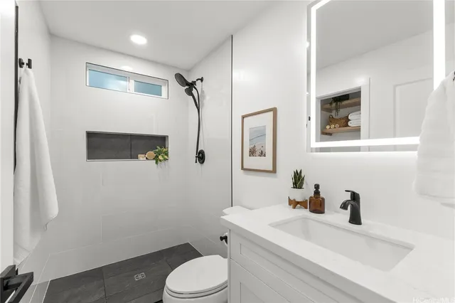 a bathroom with a sink a toilet and shower