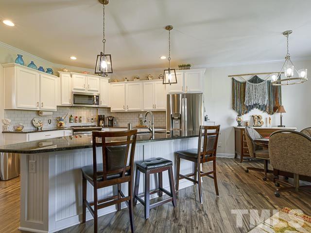 40 Fisher Road Lillington, NC 27546 - Photo 19 of 47 a kitchen with stainless steel appliances kitchen island granite countertop a dining table chairs and sink