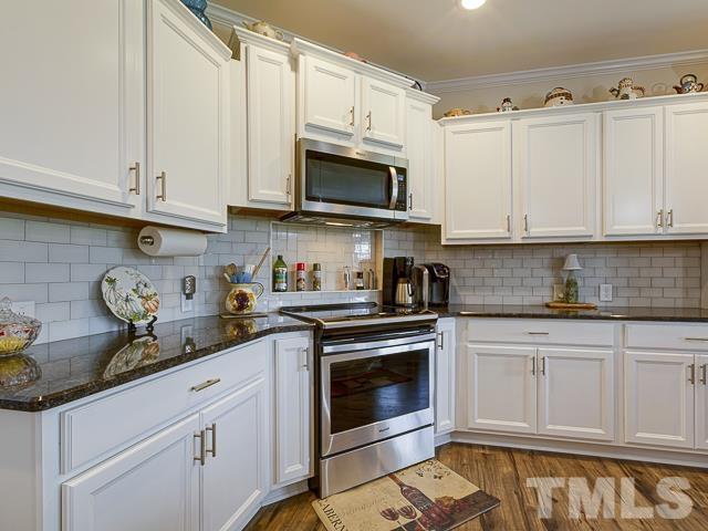 40 Fisher Road Lillington, NC 27546 - Photo 21 of 47 a kitchen with stainless steel appliances granite countertop a sink a stove and cabinets