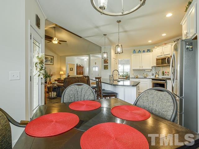 40 Fisher Road Lillington, NC 27546 - Photo 26 of 47 a kitchen with stainless steel appliances kitchen island granite countertop a dining table chairs and sink