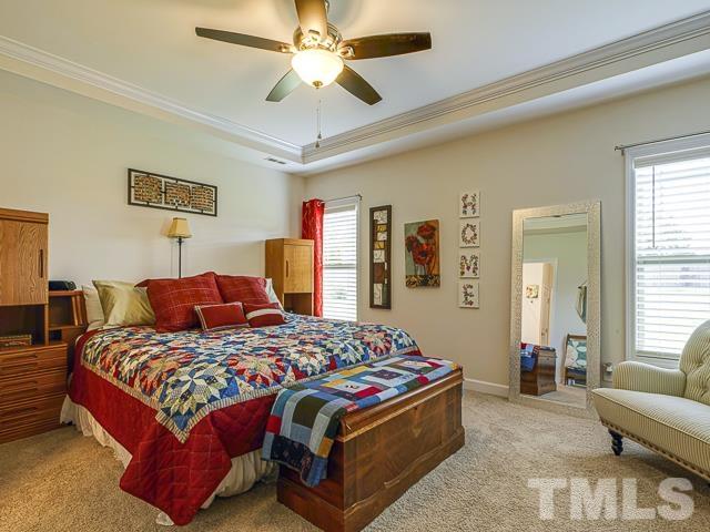 40 Fisher Road Lillington, NC 27546 - Photo 30 of 47 a bedroom with a bed and a chandelier