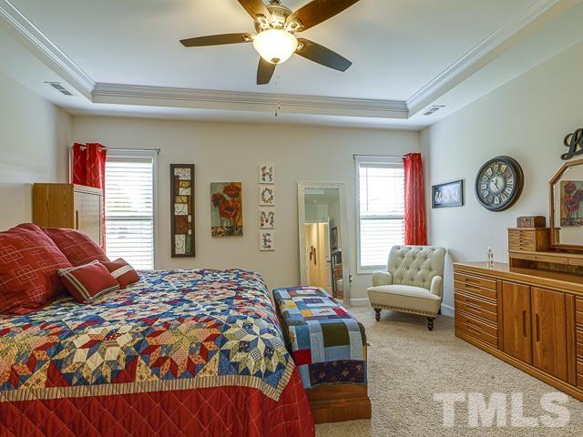 40 Fisher Road Lillington, NC 27546 - Photo 31 of 47 a bedroom with a bed and a chandelier