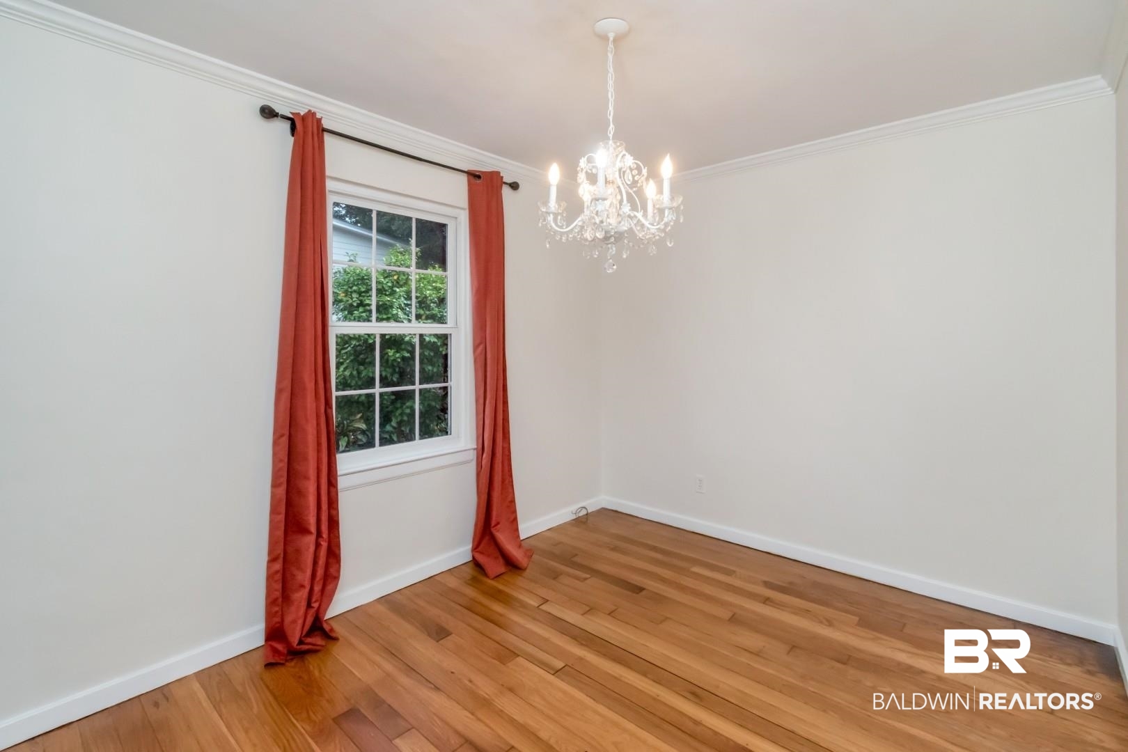 33 Lancaster Road Mobile, AL 36608 - Photo 7 of 40 Unfurnished room featuring a chandelier, light wood-type flooring, crown molding, and baseboards