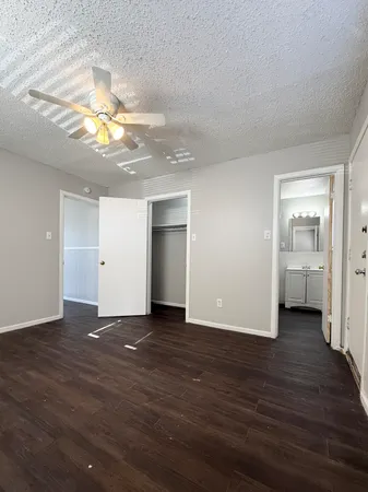 a view of a livingroom with a kitchen space with wooden floor