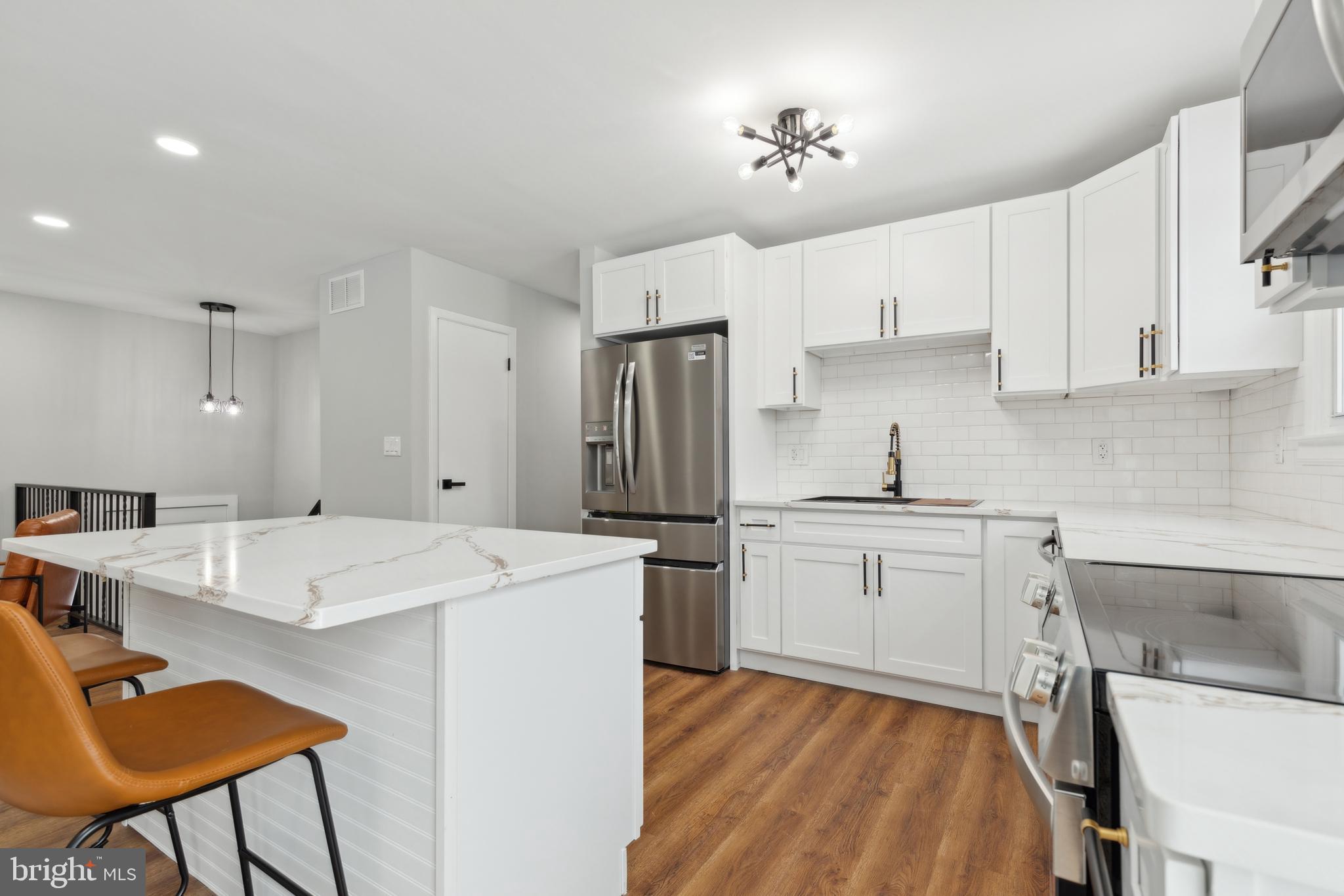 7760 Telegraph Road Severn, MD 21144 - Photo 18 of 49 a kitchen with a sink a stove a refrigerator and white cabinets