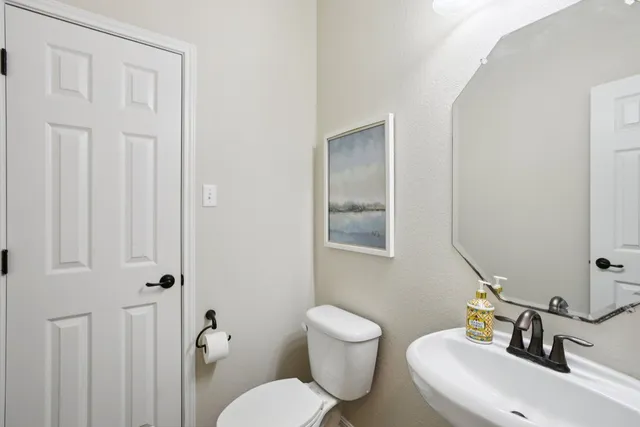 a bathroom with a toilet a sink and mirror