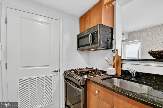 a kitchen with stainless steel appliances granite countertop a sink stove and microwave