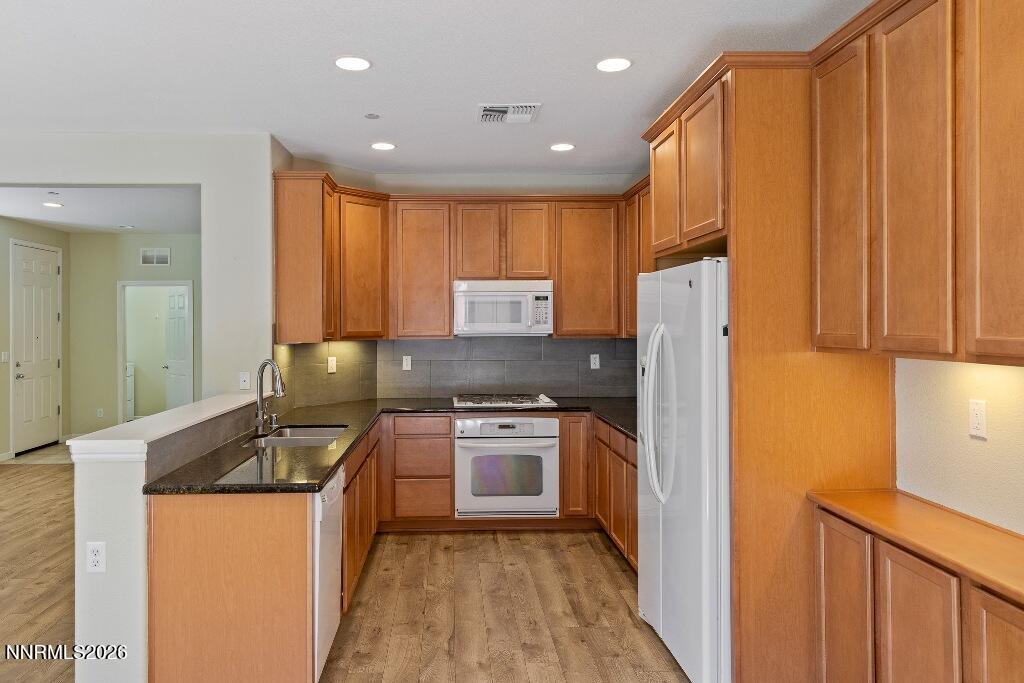 1864 Wind Ranch Road, Unit B Reno, NV 89521 - Photo 13 of 42 a kitchen with stainless steel appliances granite countertop a refrigerator a stove and a sink with wooden cabinets