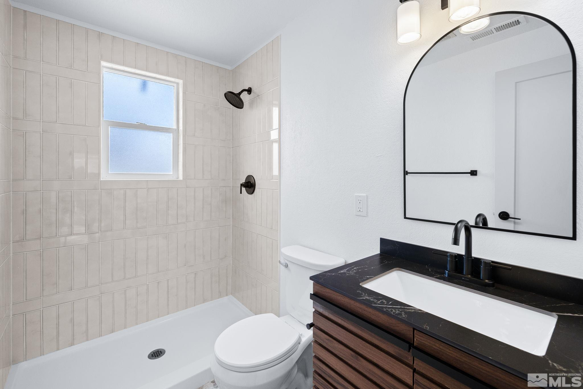 3575 Gull Street Reno, NV 89508 - Photo 19 of 32 a bathroom with a granite countertop sink a toilet and shower