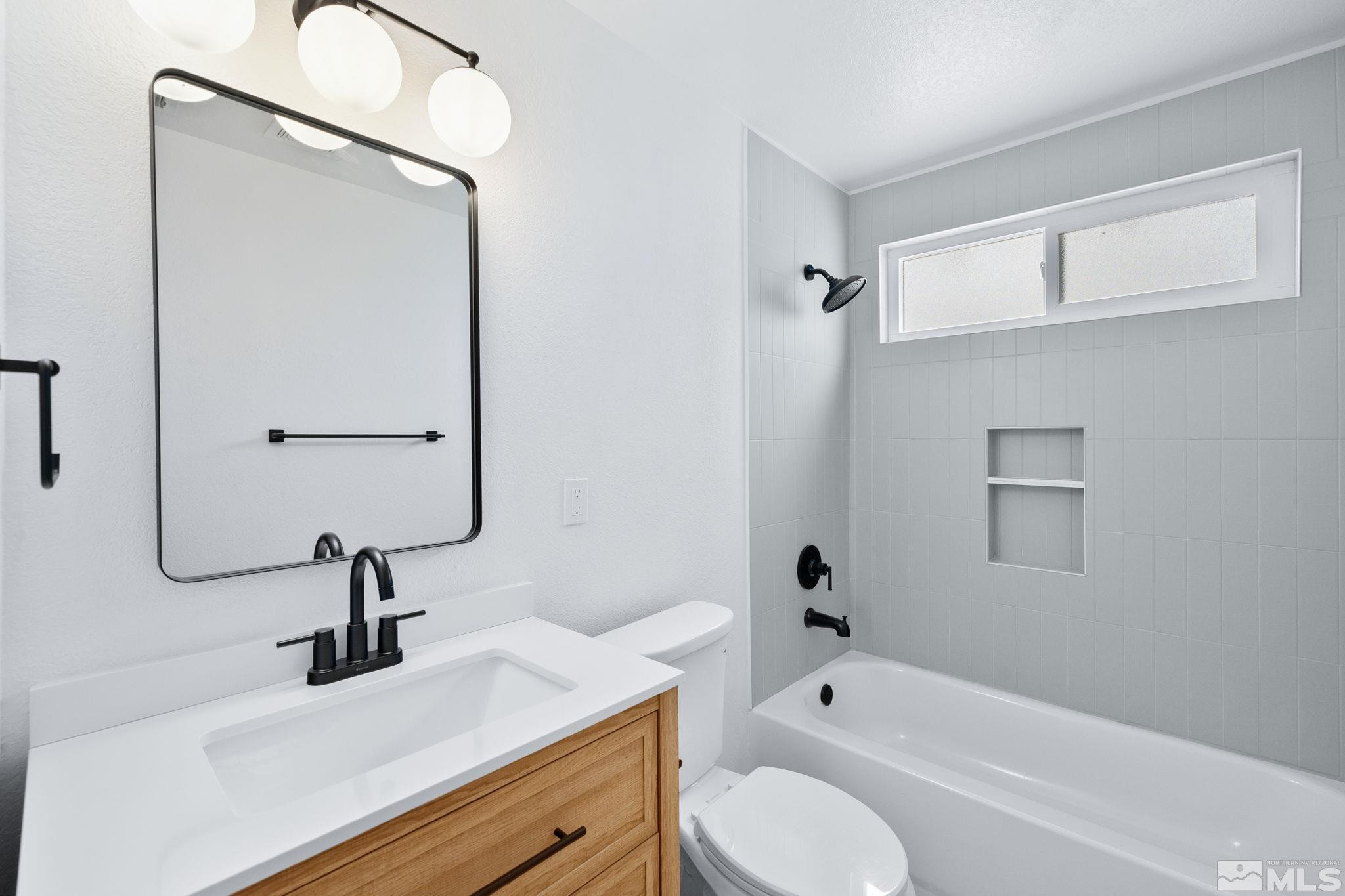 3575 Gull Street Reno, NV 89508 - Photo 25 of 32 a bathroom with a tub sink toilet and a mirror