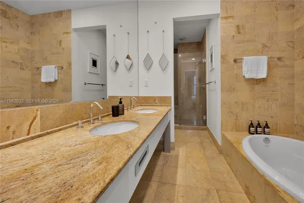 a bathroom with a granite countertop tub sink and mirror