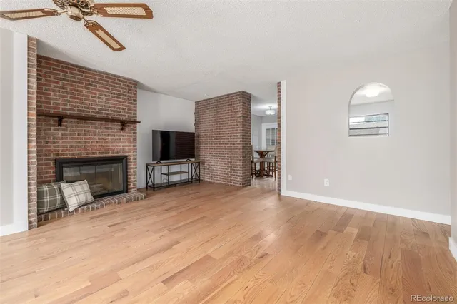 a view of empty room with wooden floor and fireplace