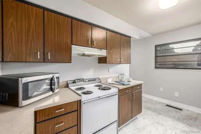 a kitchen with stainless steel appliances granite countertop wooden cabinets a stove a sink and dishwasher