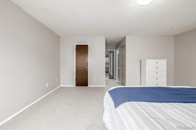 a bedroom with a large bed and chandelier