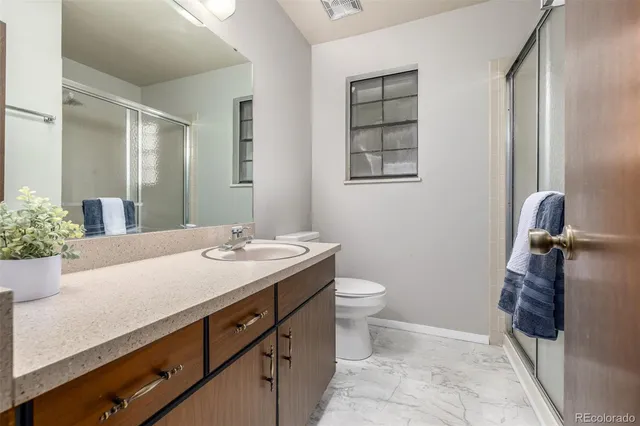a bathroom with a sink a toilet and with mirror