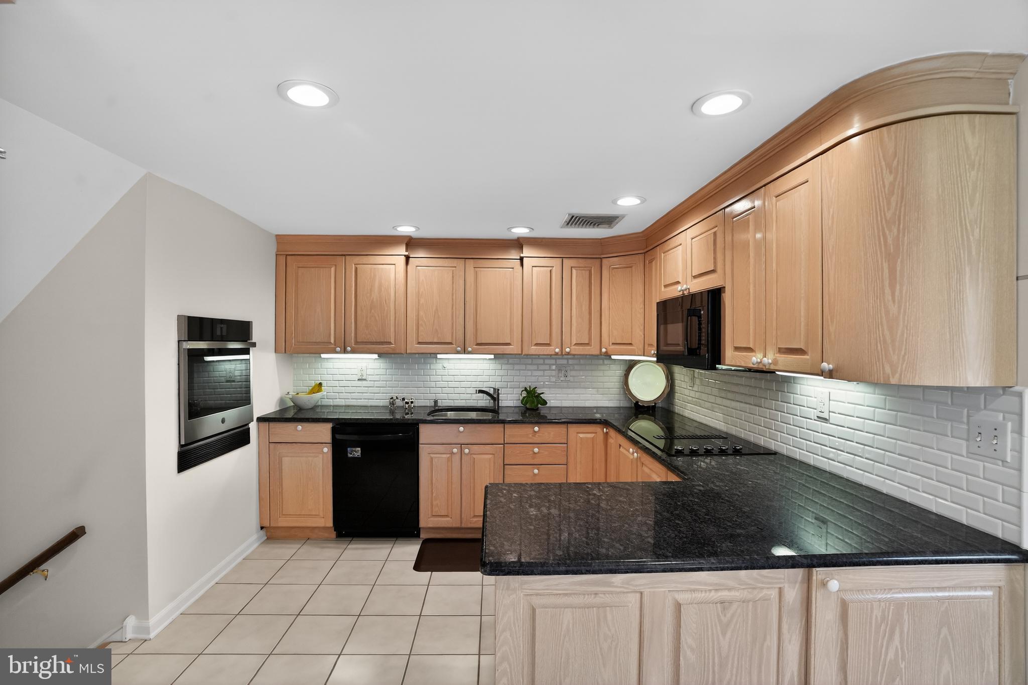 211 Fairfield Drive Wallingford, PA 19086 - Photo 7 of 29 a kitchen with stainless steel appliances granite countertop a sink a stove and cabinets