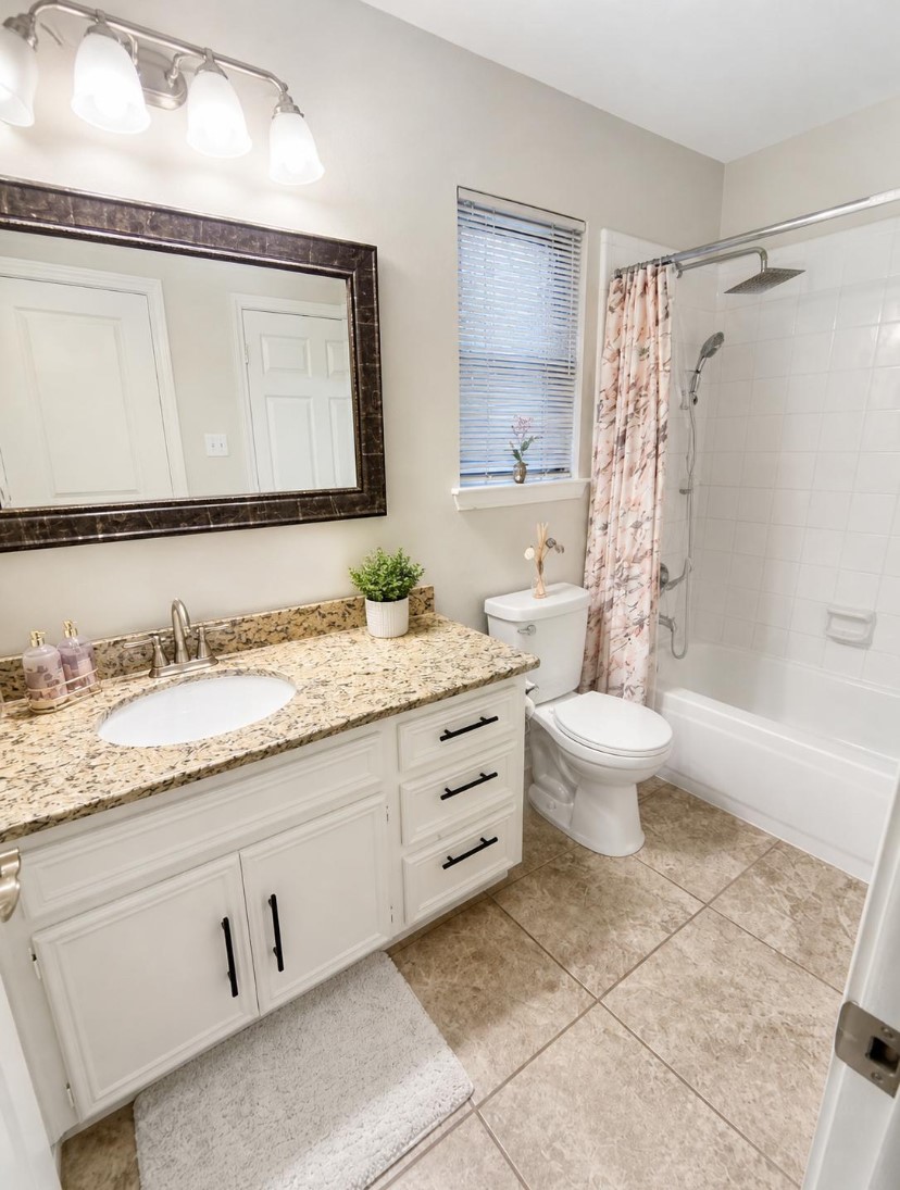 15922 Cutten Road Houston, TX 77070 - Photo 11 of 22 a bathroom with a granite countertop sink and a mirror