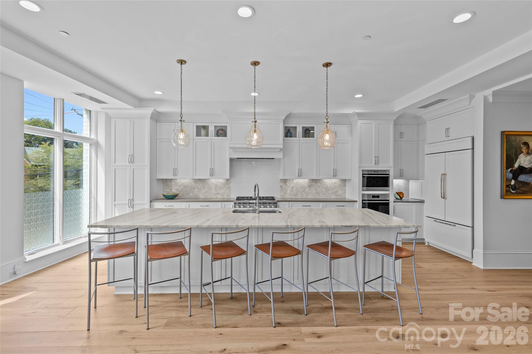 1500 Queens Road, Unit 104 Charlotte, NC 28207 - Photo 6 of 41 a large kitchen with kitchen island a dining table and chairs