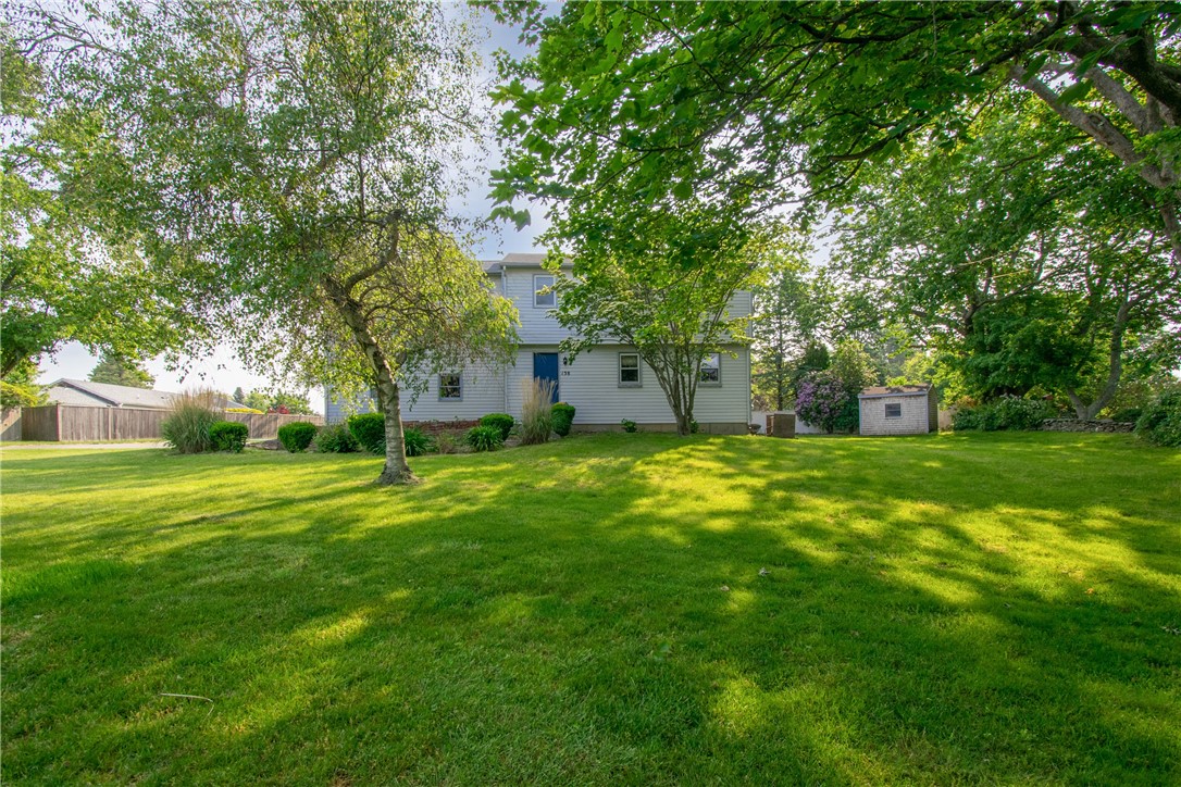 138 Oliphant sits at the end of a long driveway surrounded by mature trees and landscaping.